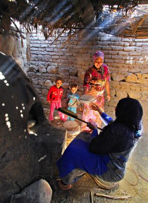 Frauen backen Brot in einem Lehmofen