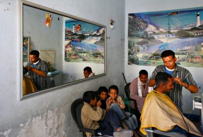 Friseur bei der Arbeit, Kinder schauen zu