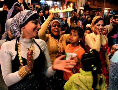 Frauen und Kinder tanzen und singen