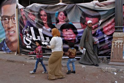 Passanten vor einem großen Werbeplakat