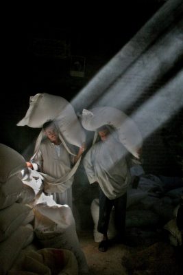 Arbeiter tragen Mehlsäcke