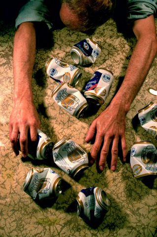 leere Bierbüchsen und Betrunkener