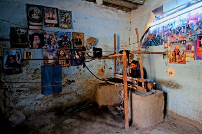 Weberin am hölzernen Webstuhl